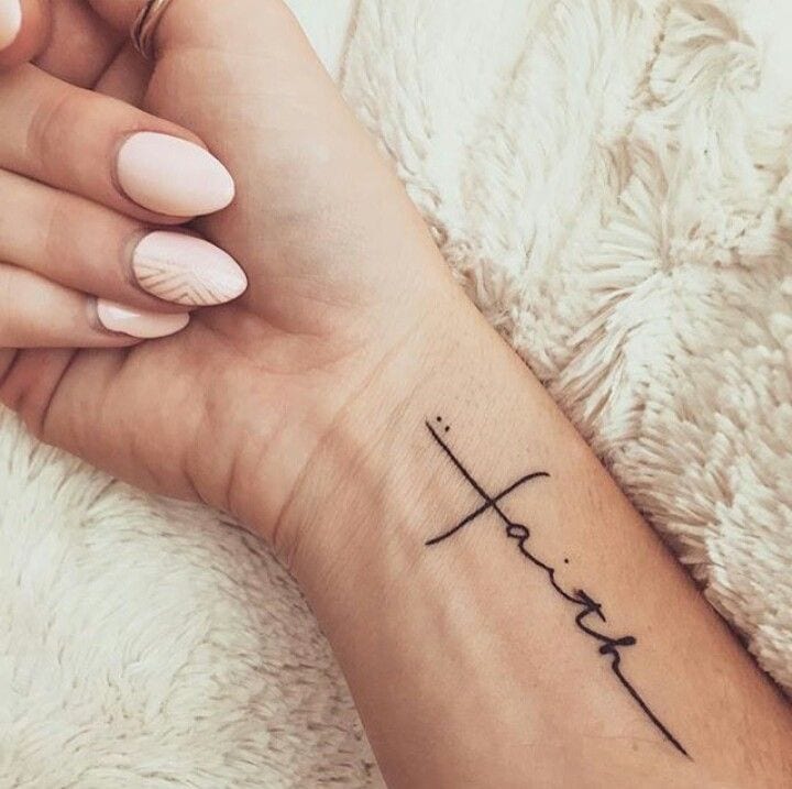 faith written into cross shape christian tattoo on wrist